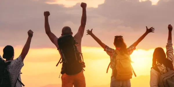 Image of four youngsters celebrating facing the sunset